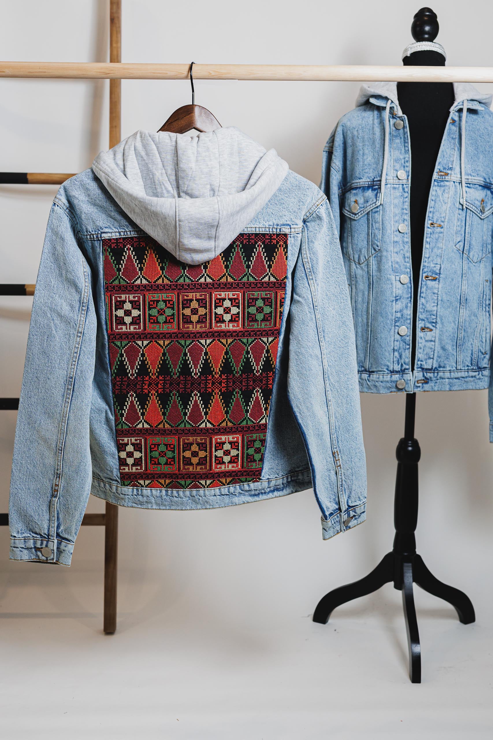 Detail view of the detachable cotton hood on the blue unisex embroidered denim jacket