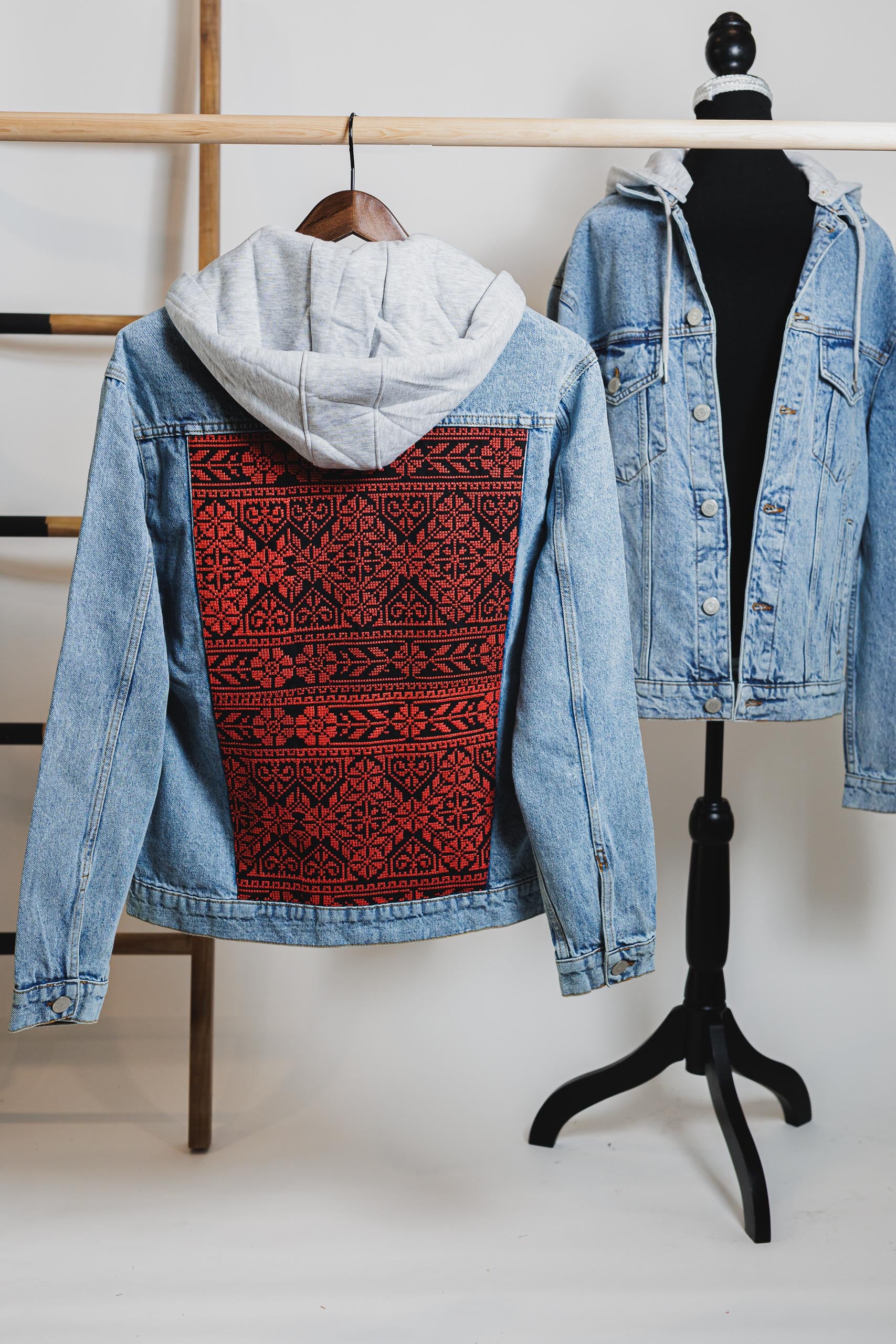 Back view of the embroidered blue unisex hooded denim jacket featuring bold Palestinian Tatreez embroidery