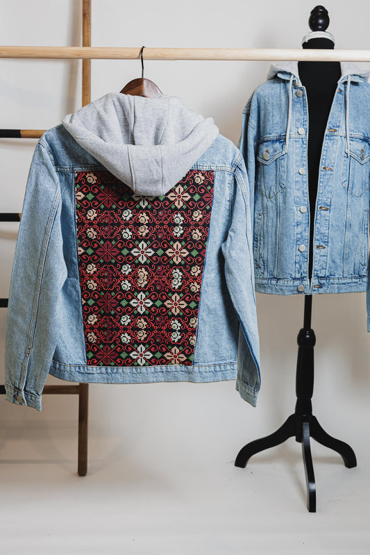 Embroidered blue unisex hooded denim jacket featuring Palestinian Tatreez design.