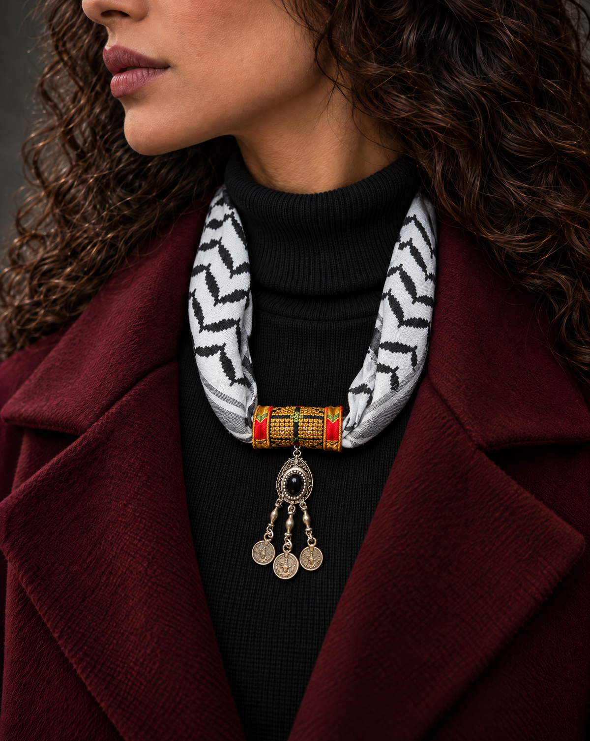 Woman wearing a Palestinian keffiyeh scarf necklace with gold tatreez band and silver-tone pendant with coin drops