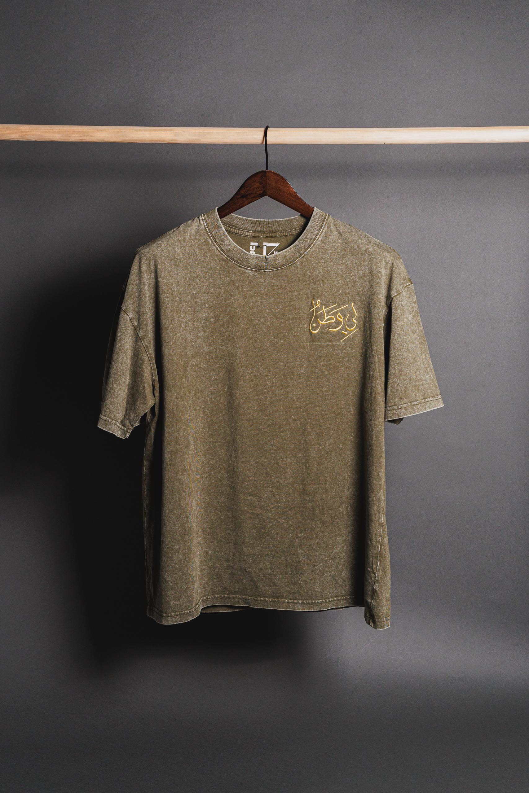 Green Watan T-shirt with embroidered 'لي وطن' on the right, symbolizing Palestinian heritage, pride, and resistance.