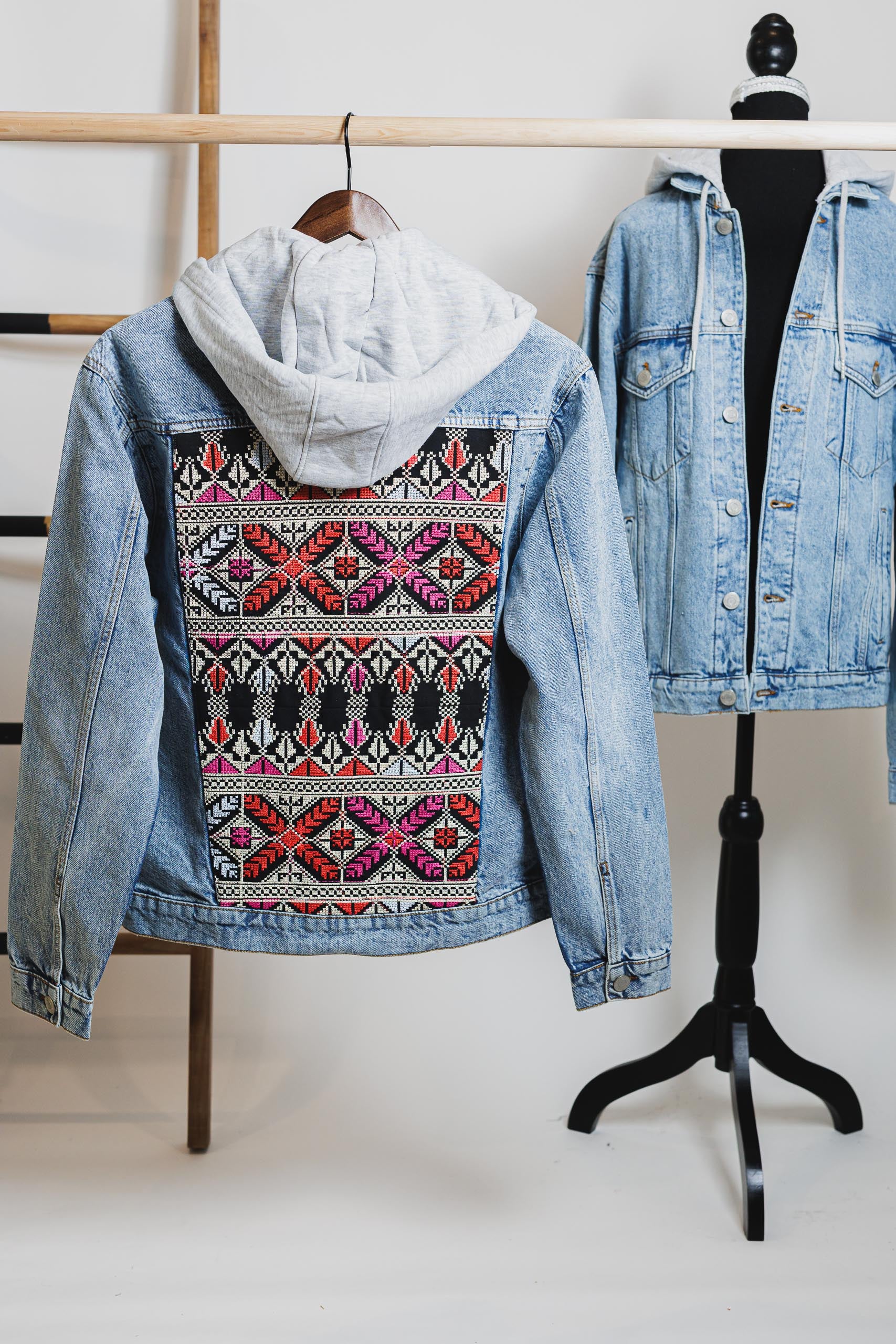 Close-up of the high-quality denim fabric and stitching on the embroidered blue unisex hooded denim jacket.