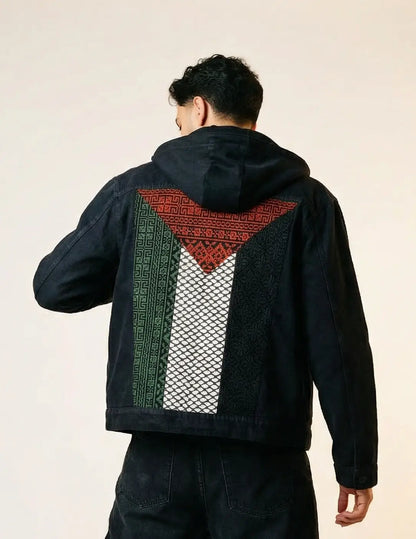 Person wearing a black jacket with a geometric pattern creating Palesting flag on a plain background