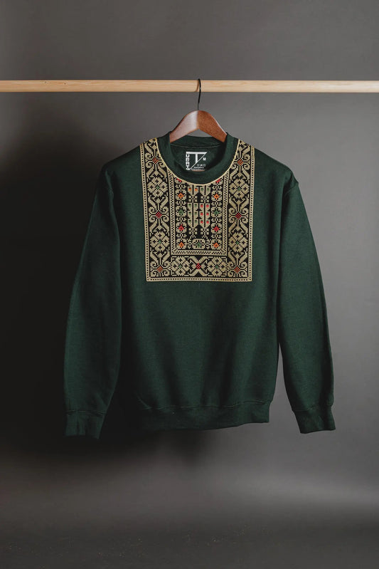 Close-up of gold Tatreez embroidery on the collar of a forest green sweatshirt