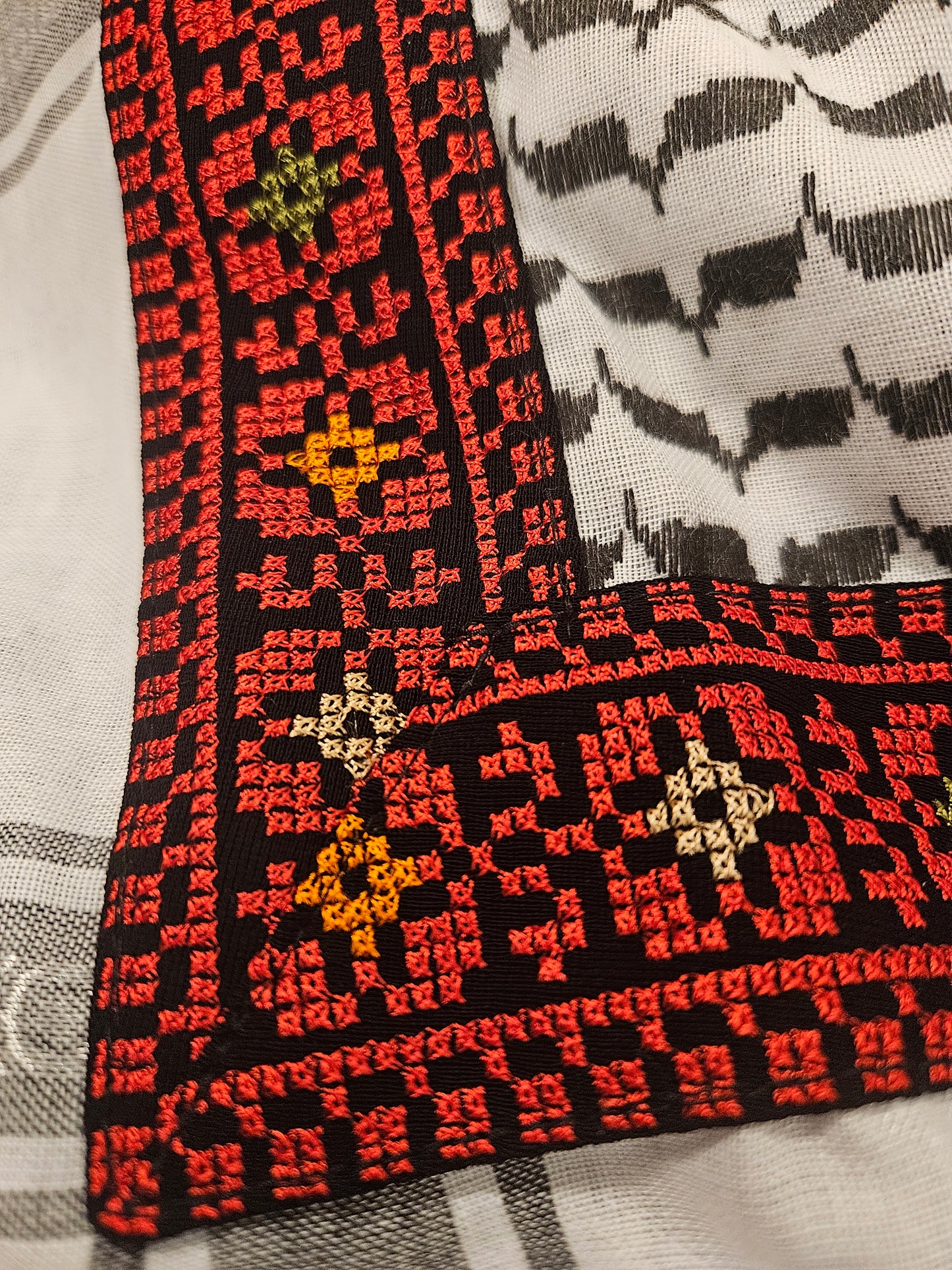 Close-up of a decorative keffiyeh bandana with intricate Tatreez embroidery, highlighting the craftsmanship and cultural significance of the design