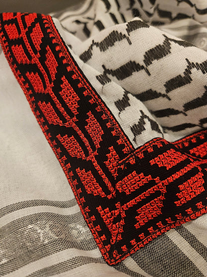 Close-up of a black and red keffiyeh bandana with traditional Tatreez embroidery, showcasing Palestinian heritage and cultural pride