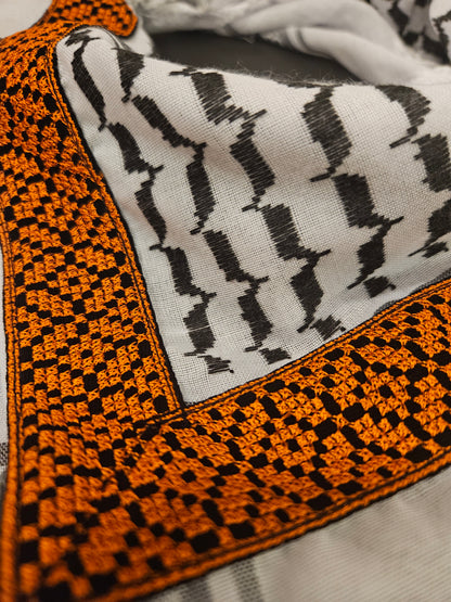 Close-up of a luxury gold keffiyeh bandana with detailed Tatreez embroidery, highlighting Palestinian heritage and intricate craftsmanship