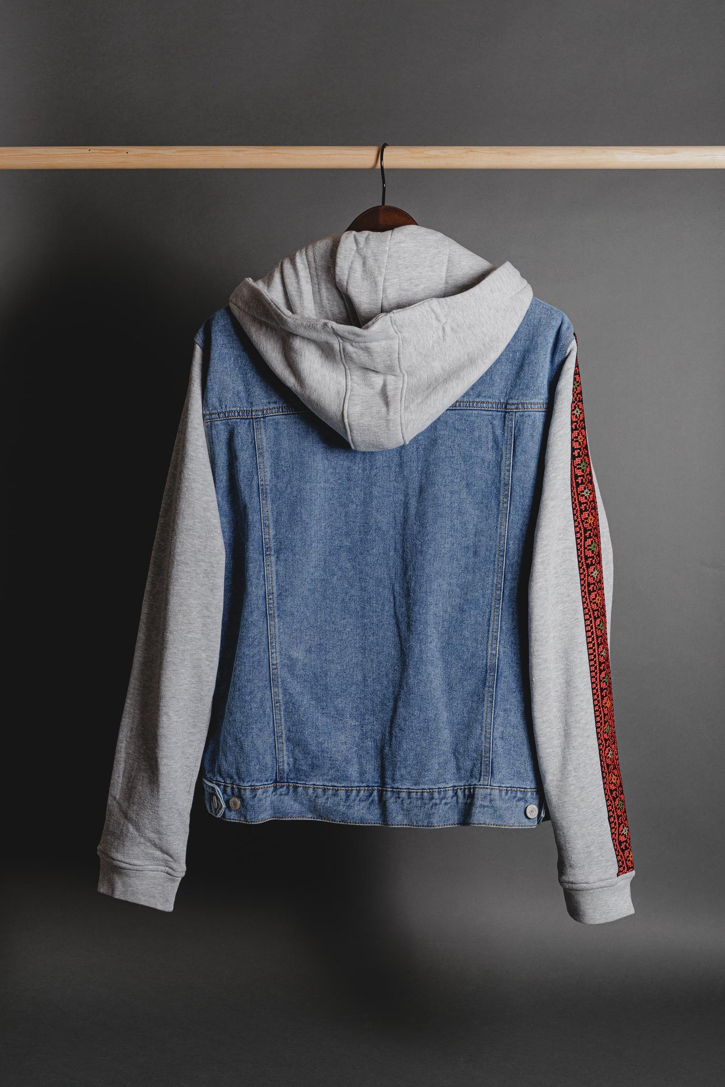 Back view of denim jacket with fleece sleeves and cultural keffiyeh-pattern detail, unisex streetwear