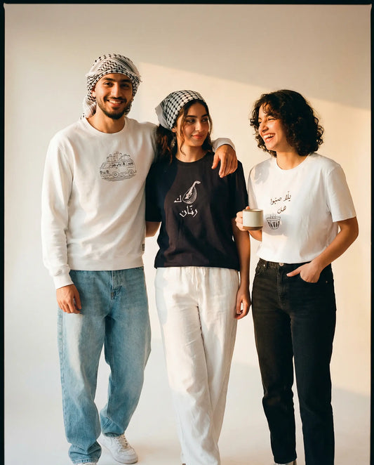 Three people standing together wearing branded clothing against a plain background