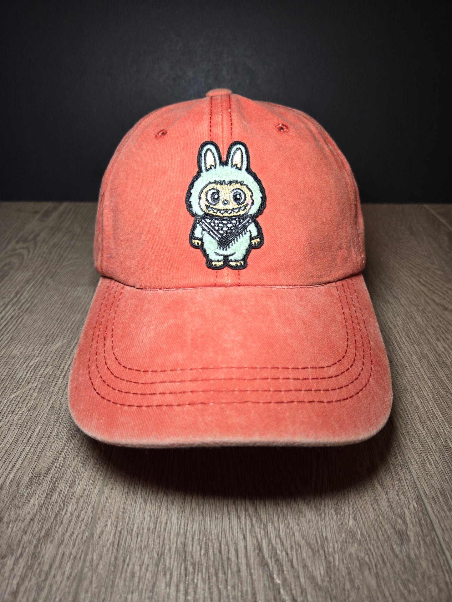 Orange cap featuring the Labubu cartoon character, a fun and vibrant embroidered design perfect for a playful look