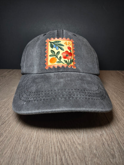 Gray unisex cap with embroidered Palestine stamp and floral design, symbolizing cultural pride